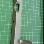 Imagen de bisagra de tapa frontal para fileteadora KC-24, fabricada con materiales resistentes para un ajuste preciso y duradero.