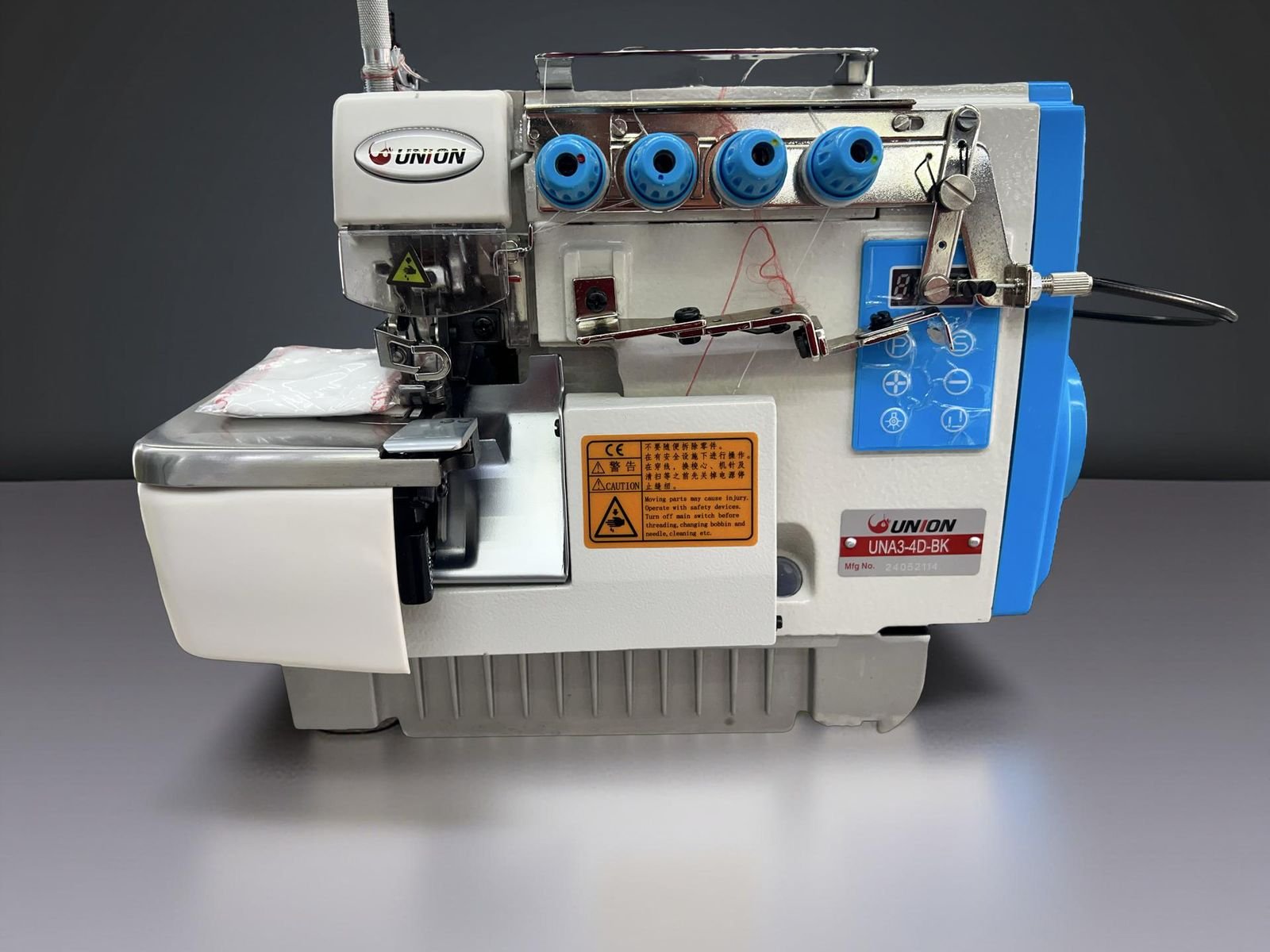 Fileteadora mecatrónica de 4 hilos con remate automático marca Union modelo UNA3-4D-BK sobre mesa industrial